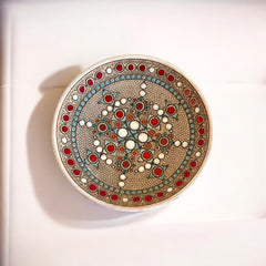 Vintage French studio pottery bowl by Paul Dordet, hand-formed in textured buff clay with red, white, and blue glazed circular motifs; signed on the underside and shown with hanging wire for optional wall display.