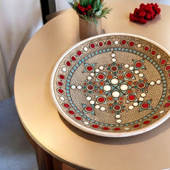 Vintage French studio pottery bowl by Paul Dordet, hand-formed in textured buff clay with red, white, and blue glazed circular motifs; signed on the underside and shown with hanging wire for optional wall display.