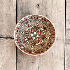 Vintage French studio pottery bowl by Paul Dordet, hand-formed in textured buff clay with red, white, and blue glazed circular motifs; signed on the underside and shown with hanging wire for optional wall display.