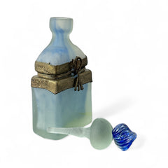 Vintage Romanian art glass perfume bottle from the 1990s, featuring frosted blue and green glass with a sculptural swirled stopper and bronze wire bow detail around the neck. Square base with a tapered neck; dauber slightly shortened due to breakage.