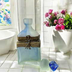 Vintage Romanian art glass perfume bottle from the 1990s, featuring frosted blue and green glass with a sculptural swirled stopper and bronze wire bow detail around the neck. Square base with a tapered neck; dauber slightly shortened due to breakage.