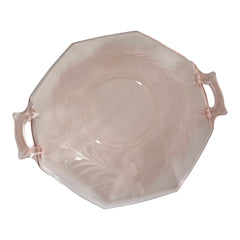 Vintage pink Depression glass serving dish with etched floral design and dual handles, styled on marble with soft lighting to highlight its shape, color, and collectible charm.