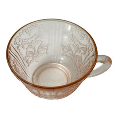 Vintage pink depression glass set featuring 2 delicate cups from the American Sweetheart collection and 2 square saucers from the Madrid collection, both adorned with intricate floral and geometric etched patterns. A timeless and sustainable addition to any table or décor.