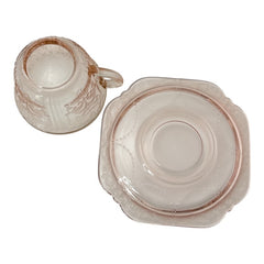 Vintage pink depression glass set featuring 2 delicate cups from the American Sweetheart collection and 2 square saucers from the Madrid collection, both adorned with intricate floral and geometric etched patterns. A timeless and sustainable addition to any table or décor.