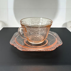 Vintage pink depression glass set featuring 2 delicate cups from the American Sweetheart collection and 2 square saucers from the Madrid collection, both adorned with intricate floral and geometric etched patterns. A timeless and sustainable addition to any table or décor.