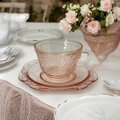 Vintage pink depression glass set featuring 2 delicate cups from the American Sweetheart collection and 2 square saucers from the Madrid collection, both adorned with intricate floral and geometric etched patterns. A timeless and sustainable addition to any table or décor.