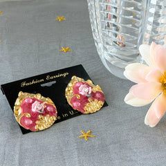 Vintage 1980s teardrop post earrings with 3D pink polymer clay rose, pink enamel base, and gold tone pressed metal scrollwork on original card.