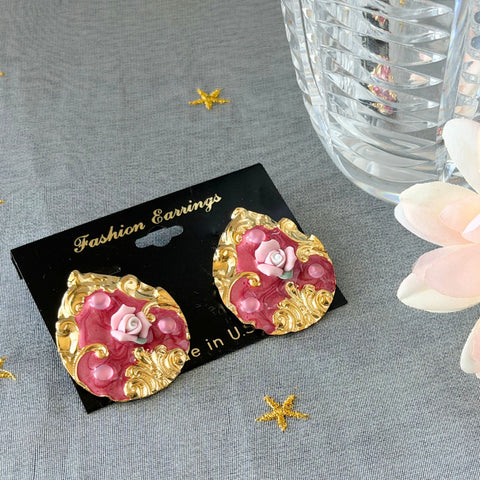 Vintage 1980s teardrop post earrings with 3D pink polymer clay rose, pink enamel base, and gold tone pressed metal scrollwork on original card.