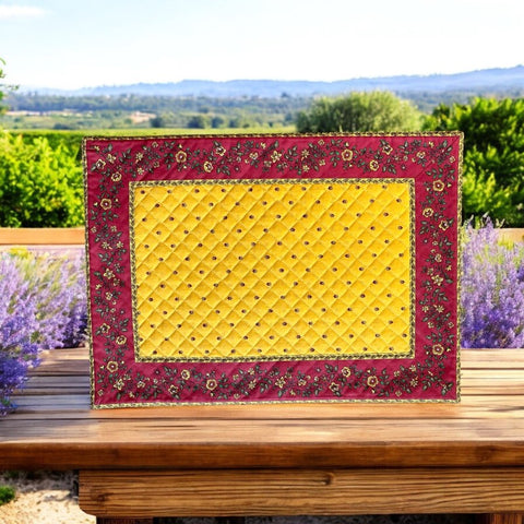 Reversible quilted cotton placemat in Fleurette Yellow Red by Marat d’Avignon, featuring a red diamond-quilted center with petite golden florals and yellow floral scroll borders on the front, and an allover red reverse with red floral accents, crafted in Provence.