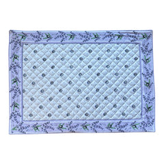 Reversible quilted cotton placemat in Lauris Light Yellow by Marat d’Avignon, featuring a white center with lavender purple floral medallions and a border of lavender sprigs and olive branches, with a white reverse side  scattered with tiny lavender  blossoms, crafted in Provence.