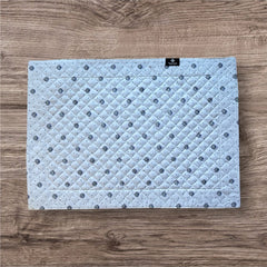 Reversible quilted cotton placemat in Lauris Light Yellow by Marat d’Avignon, featuring a white center with lavender purple floral medallions and a border of lavender sprigs and olive branches, with a white reverse side  scattered with tiny lavender  blossoms, crafted in Provence.