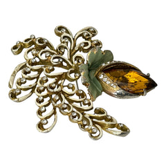 Vintage H. Pomerantz floral brooch featuring a large topaz-colored marquise rhinestone set in gold-tone metal, accented with green and cream enamel leaves and clear rhinestones; signed on the reverse, circa 1940s, measuring 3 inches by 3 inches.