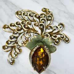 Vintage H. Pomerantz floral brooch featuring a large topaz-colored marquise rhinestone set in gold-tone metal, accented with green and cream enamel leaves and clear rhinestones; signed on the reverse, circa 1940s, measuring 3 inches by 3 inches.