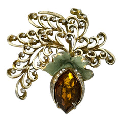 Vintage H. Pomerantz floral brooch featuring a large topaz-colored marquise rhinestone set in gold-tone metal, accented with green and cream enamel leaves and clear rhinestones; signed on the reverse, circa 1940s, measuring 3 inches by 3 inches.