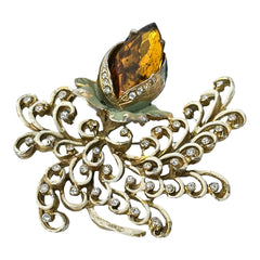 Vintage H. Pomerantz floral brooch featuring a large topaz-colored marquise rhinestone set in gold-tone metal, accented with green and cream enamel leaves and clear rhinestones; signed on the reverse, circa 1940s, measuring 3 inches by 3 inches.