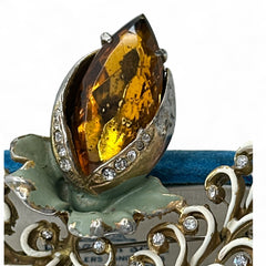 Vintage H. Pomerantz floral brooch featuring a large topaz-colored marquise rhinestone set in gold-tone metal, accented with green and cream enamel leaves and clear rhinestones; signed on the reverse, circa 1940s, measuring 3 inches by 3 inches.