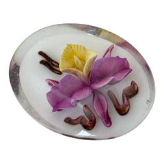 Vintage French reverse carved Lucite brooch featuring a hand-painted pink and yellow orchid on a white background. Oval shape with dimensional floral detail, excellent condition, circa 1950s.