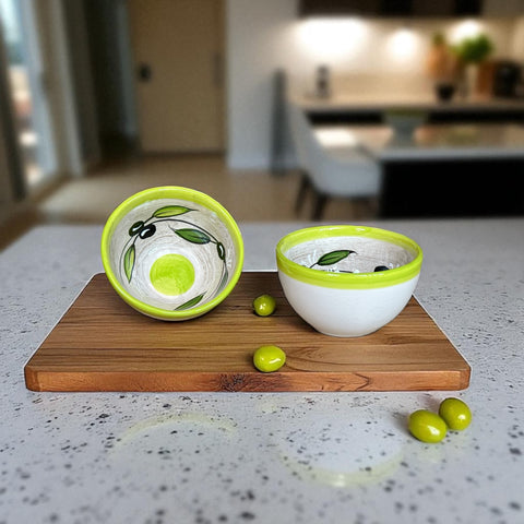 Small round ceramic bowl with green interior and rim, hand-painted with swirling olive branches, black olives, and green leaves on a beige base; measures 4 inches in diameter and 2.5 inches high.