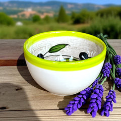 Small round ceramic bowl with green interior and rim, hand-painted with swirling olive branches, black olives, and green leaves on a beige base; measures 4 inches in diameter and 2.5 inches high.