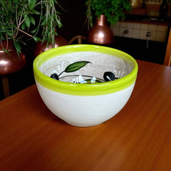 Small round ceramic bowl with green interior and rim, hand-painted with swirling olive branches, black olives, and green leaves on a beige base; measures 4 inches in diameter and 2.5 inches high.
