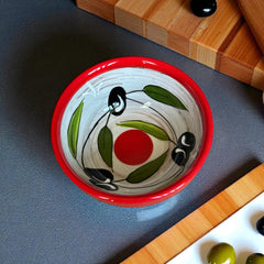 Mini ceramic bowl with red rim and white base, hand-painted with black olives and green leaves; measures 3¾ inches in diameter and 1¾ inches high, ideal for condiments or small servings.