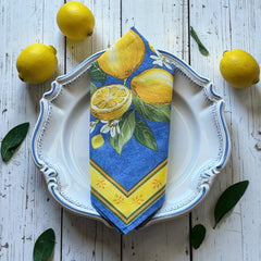 Provence cotton napkins in blue with yellow lemon motif, green leaves, and delicate lemon blossoms.