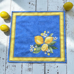 Provence cotton napkins in blue with yellow lemon motif, green leaves, and delicate lemon blossoms.