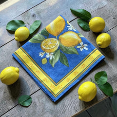 Provence cotton napkins in blue with yellow lemon motif, green leaves, and delicate lemon blossoms.