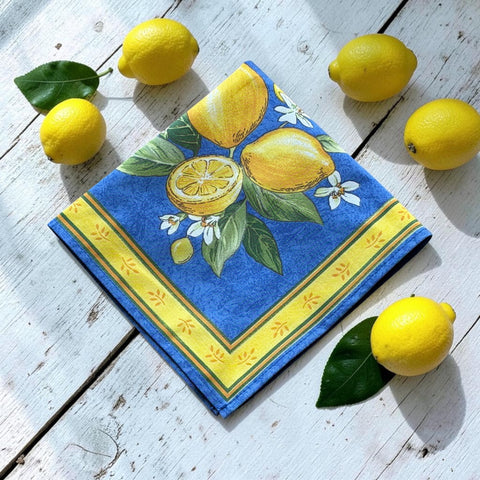 Provence cotton napkins in blue with yellow lemon motif, green leaves, and delicate lemon blossoms.