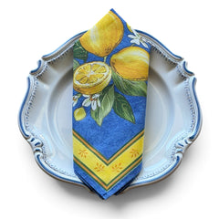 Provence cotton napkins in blue with yellow lemon motif, green leaves, and delicate lemon blossoms.