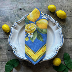 Provence cotton napkins in blue with yellow lemon motif, green leaves, and delicate lemon blossoms.