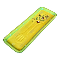 Rectangular ceramic spoon rest with yellow interior and green polka-dot rim, featuring hand-painted olive leaves, red berries, and whimsical fork and spoon motif; measures 11 by 4 inches.