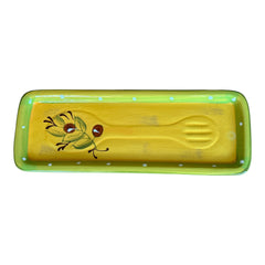Rectangular ceramic spoon rest with yellow interior and green polka-dot rim, featuring hand-painted olive leaves, red berries, and whimsical fork and spoon motif; measures 11 by 4 inches.