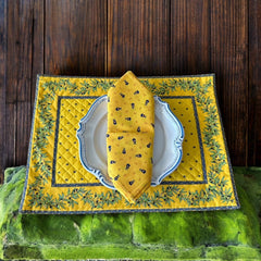 Provence cotton napkins featuring a yellow background with blue and yellow floral designs from Marat d’Avignon Tradition Collection, made of 100% cotton, measuring 18" x 18", with vibrant, fade-resistant prints. Made in France.