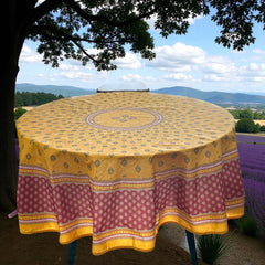 Round coated cotton tablecloth in golden yellow and deep red, featuring concentric Provençal floral and geometric patterns