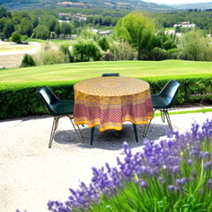 Round coated cotton tablecloth in golden yellow and deep red, featuring concentric Provençal floral and geometric patterns