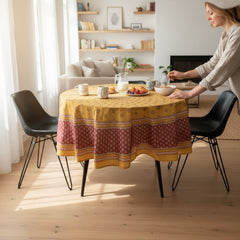 Round coated cotton tablecloth in golden yellow and deep red, featuring concentric Provençal floral and geometric patterns