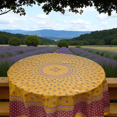 Round coated cotton tablecloth in golden yellow and deep red, featuring concentric Provençal floral and geometric patterns
