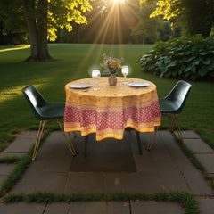 Round coated cotton tablecloth in golden yellow and deep red, featuring concentric Provençal floral and geometric patterns