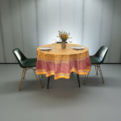 Round coated cotton tablecloth in golden yellow and deep red, featuring concentric Provençal floral and geometric patterns