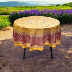 Round coated cotton tablecloth in golden yellow and deep red, featuring concentric Provençal floral and geometric patterns
