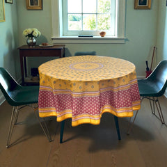 Round coated cotton tablecloth in golden yellow and deep red, featuring concentric Provençal floral and geometric patterns