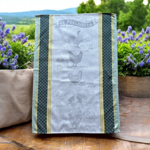 Provence tea towel featuring Le Poulailler design with rooster, hen, eggs, chicks, and chicken motifs. Center in natural and light gray tones, bordered with yellow stripes, dark green checkered pattern, and lighter green edges. Made of 100% cotton, ideal for French farmyard decor.