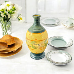 Handmade ceramic oil bottle or vase from Provence, featuring a yellow glaze with green accents and hand-painted white floral motif, signed Bleu d’Argile France