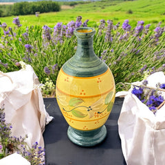 Handmade ceramic oil bottle or vase from Provence, featuring a yellow glaze with green accents and hand-painted white floral motif, signed Bleu d’Argile France