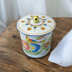 Round cookie tin box in Quimper designs, available in Floral or Rooster patterns. Cylindrical tin with a moisture-absorbing lid for keeping cookies fresh. Perfect for adding a French country charm to your kitchen.