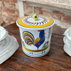 Round cookie tin box in Quimper designs, available in Floral or Rooster patterns. Cylindrical tin with a moisture-absorbing lid for keeping cookies fresh. Perfect for adding a French country charm to your kitchen.