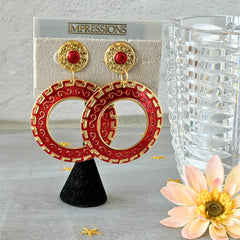 Vintage 1980s red enamel and gold‑tone circle dangle post earrings with pressed scroll and Greek key design on original Impressions card.