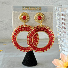 Vintage 1980s red enamel and gold‑tone circle dangle post earrings with pressed scroll and Greek key design on original Impressions card.