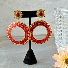 Vintage 1980s red enamel and gold‑tone circle dangle post earrings with pressed scroll and Greek key design on original Impressions card.